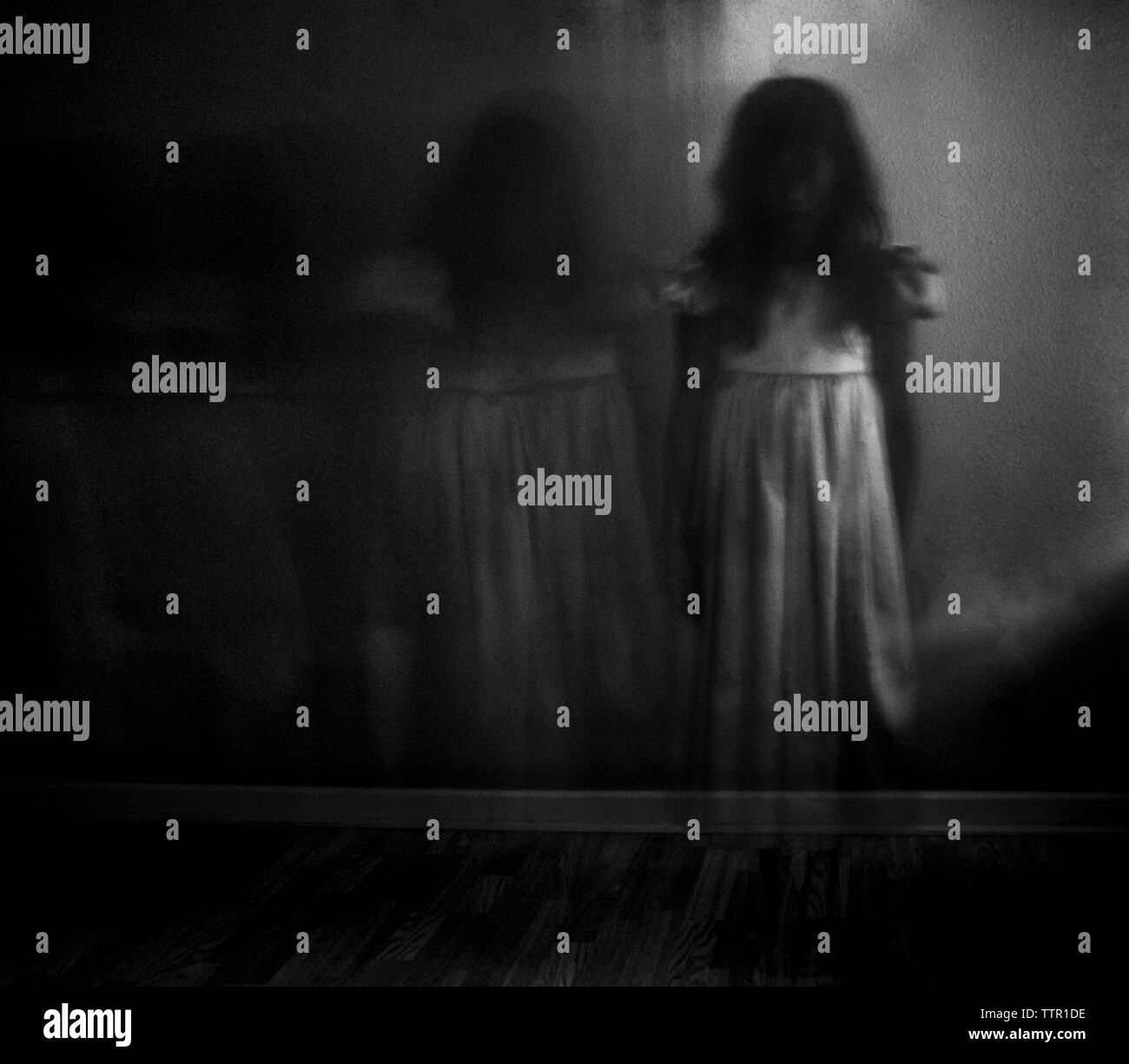 Doppia esposizione della ragazza spooky contro la parete a casa Foto Stock