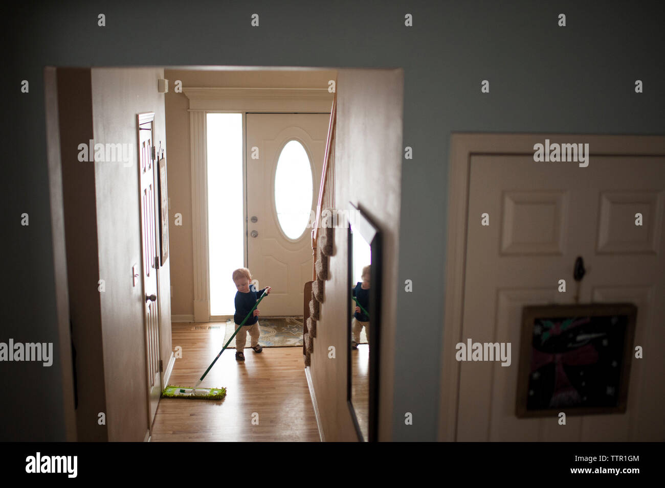Lunghezza completa di baby boy tergi pavimento in legno con la radazza a casa Foto Stock