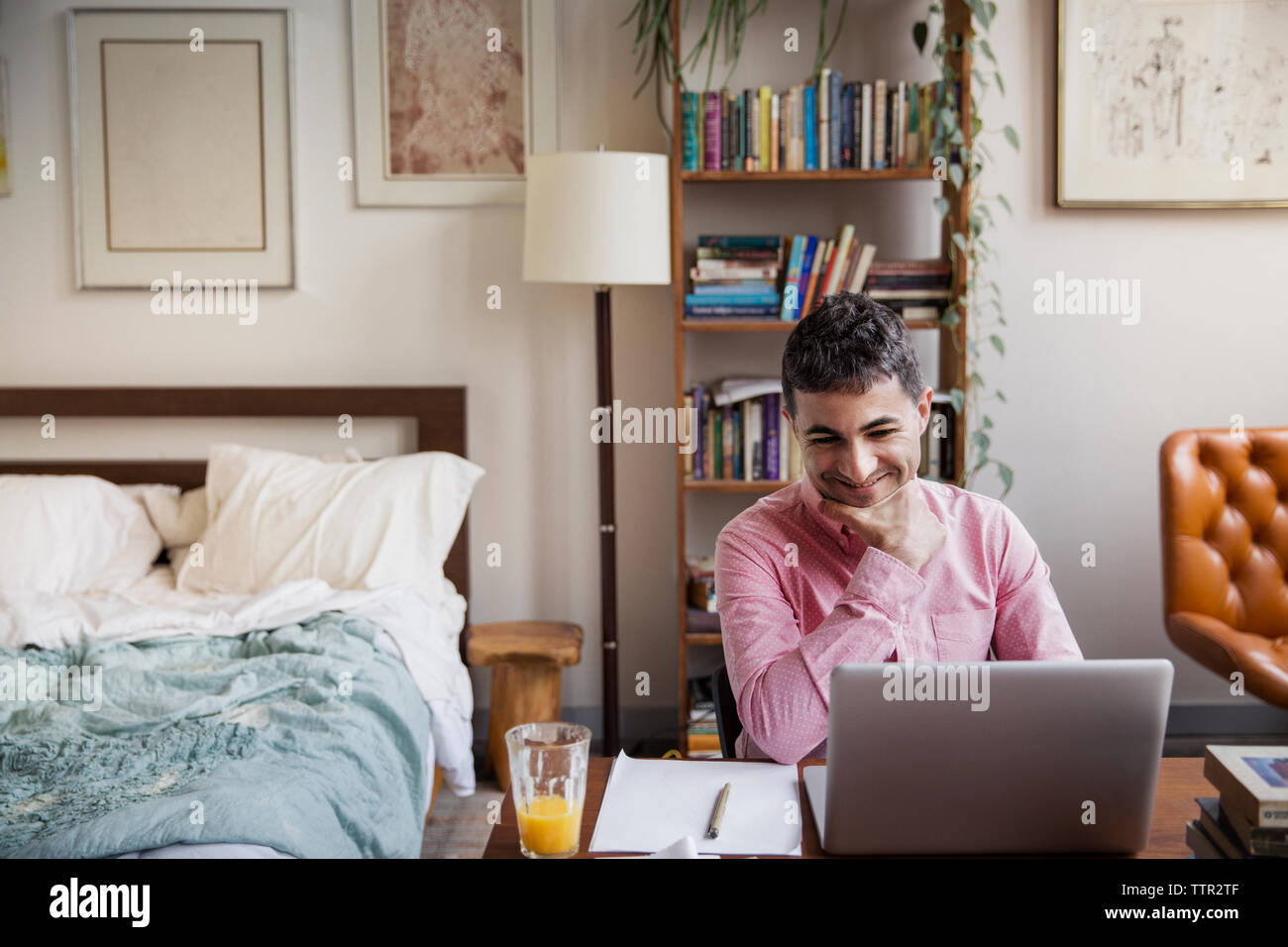 Uomo felice video conferenze sul portatile a casa Foto Stock