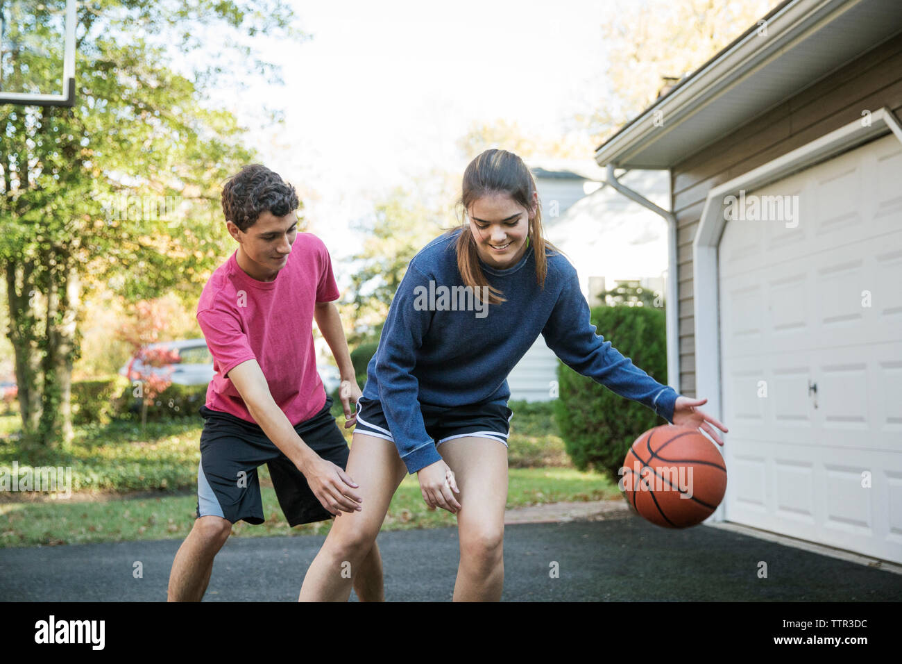 Felice fratello e sorella di giocare a basket a backyard Foto Stock