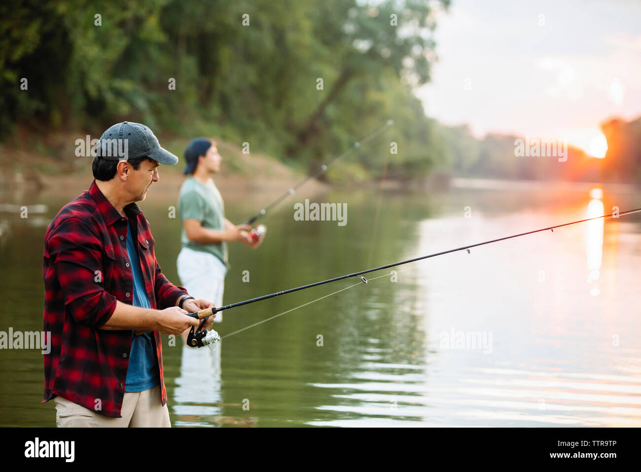 Amici di sesso maschile la pesca nel lago Foto Stock