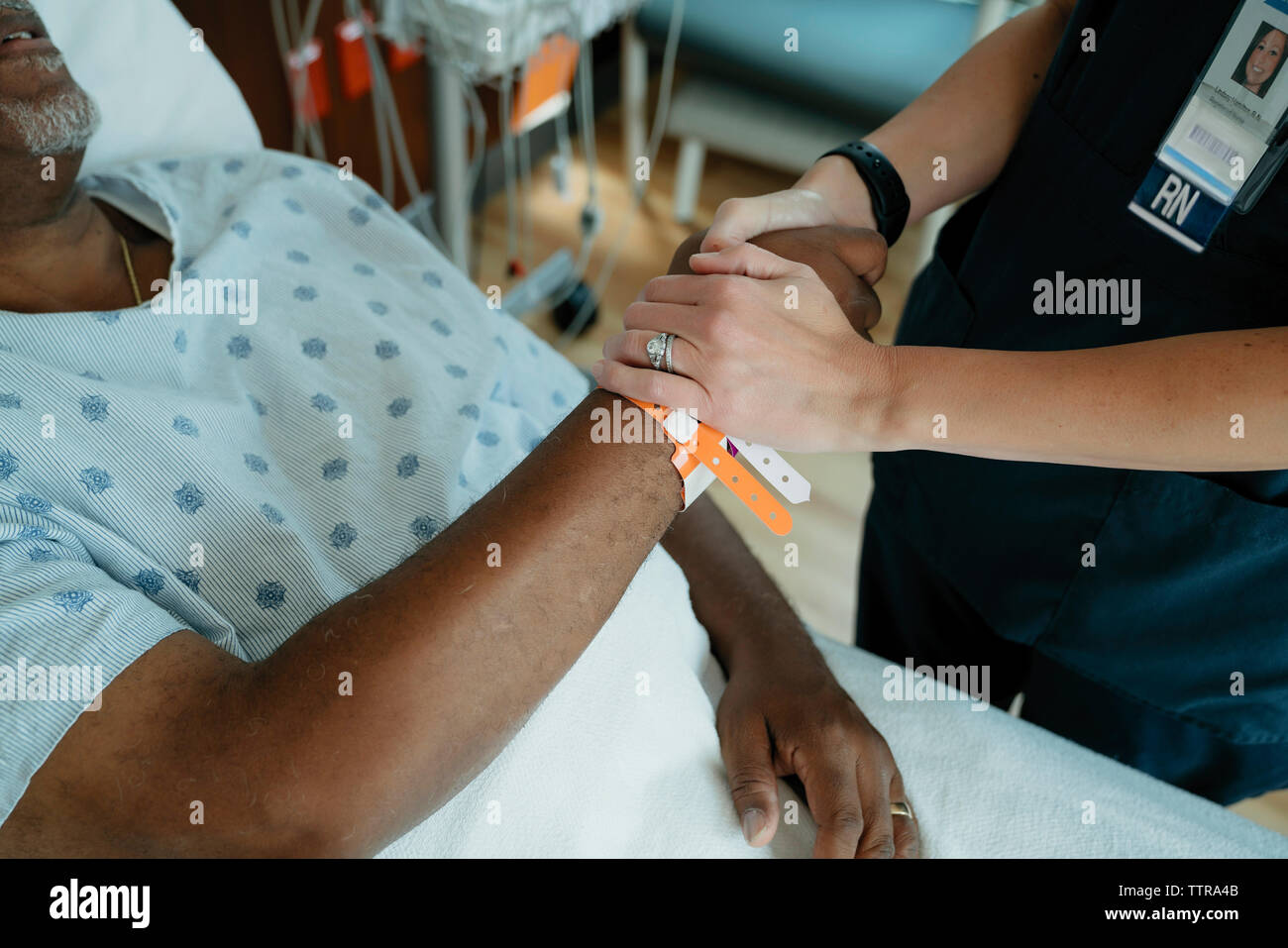 Close-up di infermiere consolante senior paziente in ospedale Foto Stock