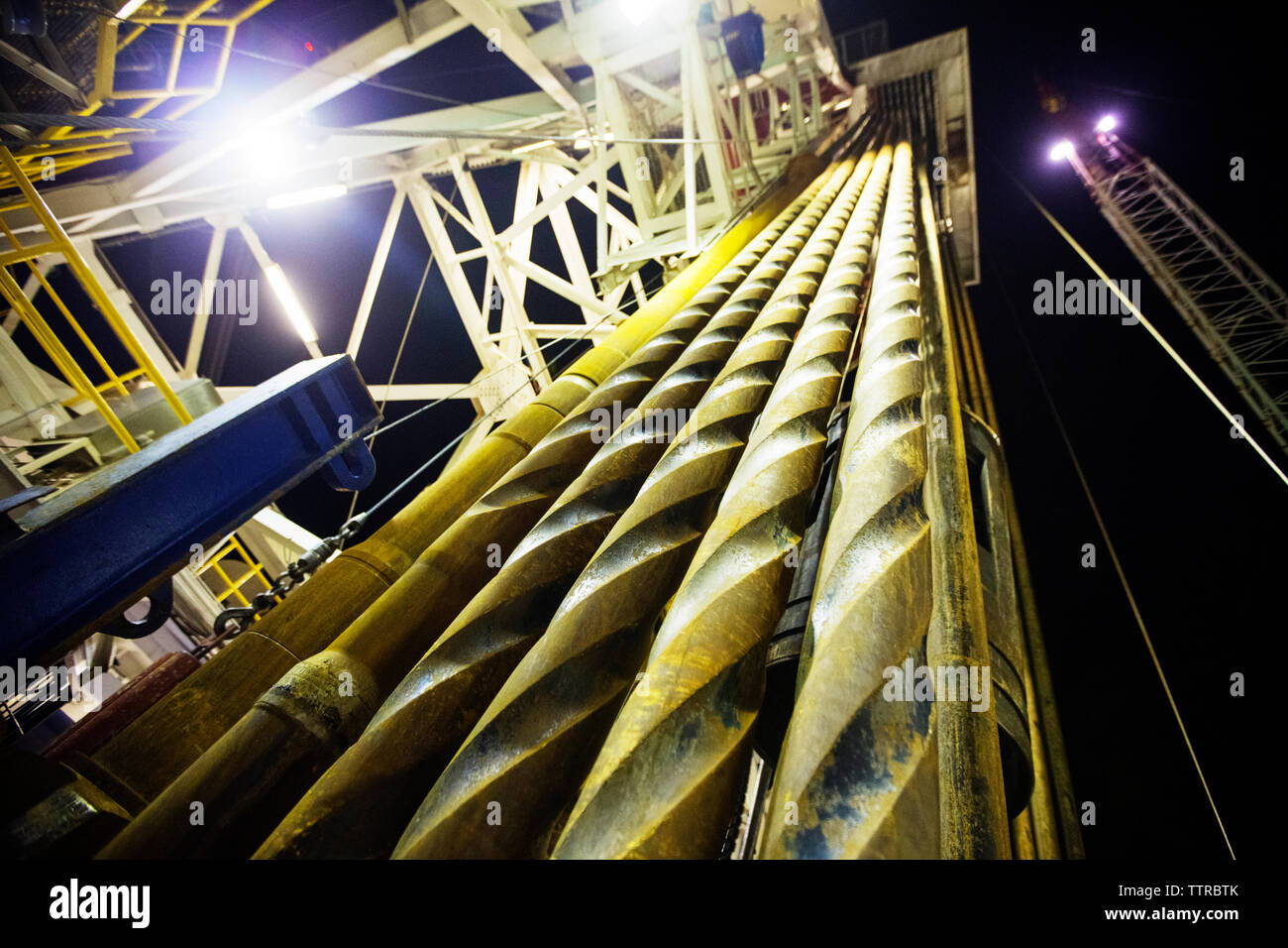 Basso angolo di visione del macchinario metallico in oil rig contro il cielo di notte Foto Stock