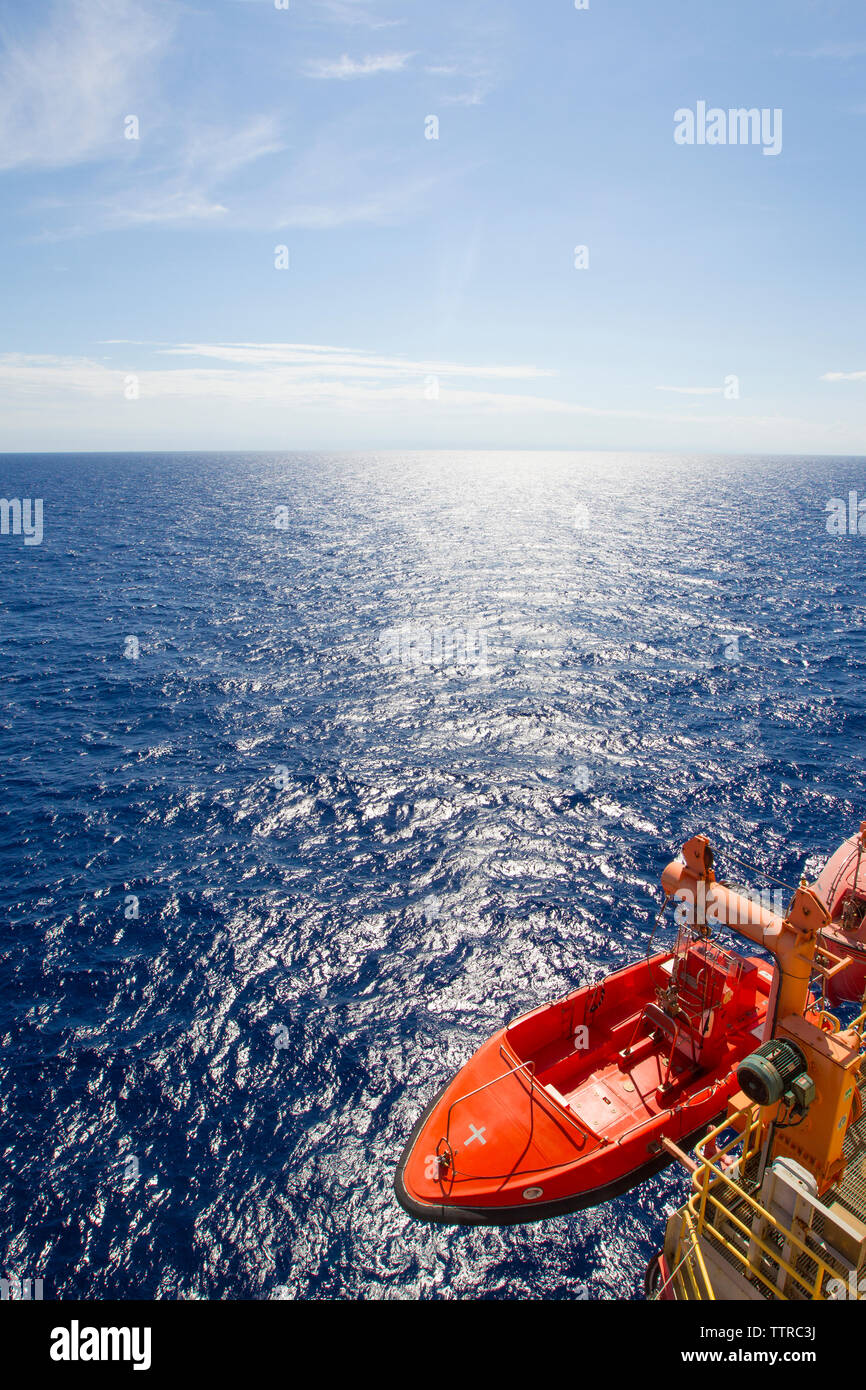 Elevato angolo di visione della barca alla piattaforma offshore contro sky durante la giornata di sole Foto Stock