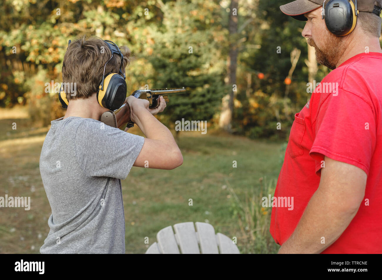 Padre guardando il figlio di tiro al cortile Foto Stock