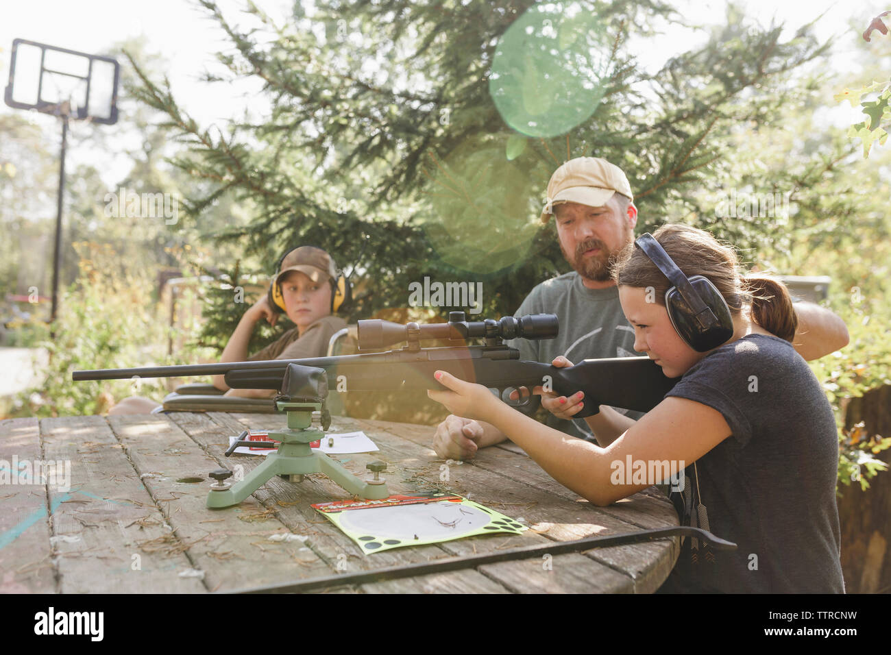 Padre e figlio guardando la ragazza tiro al bersaglio a backyard Foto Stock