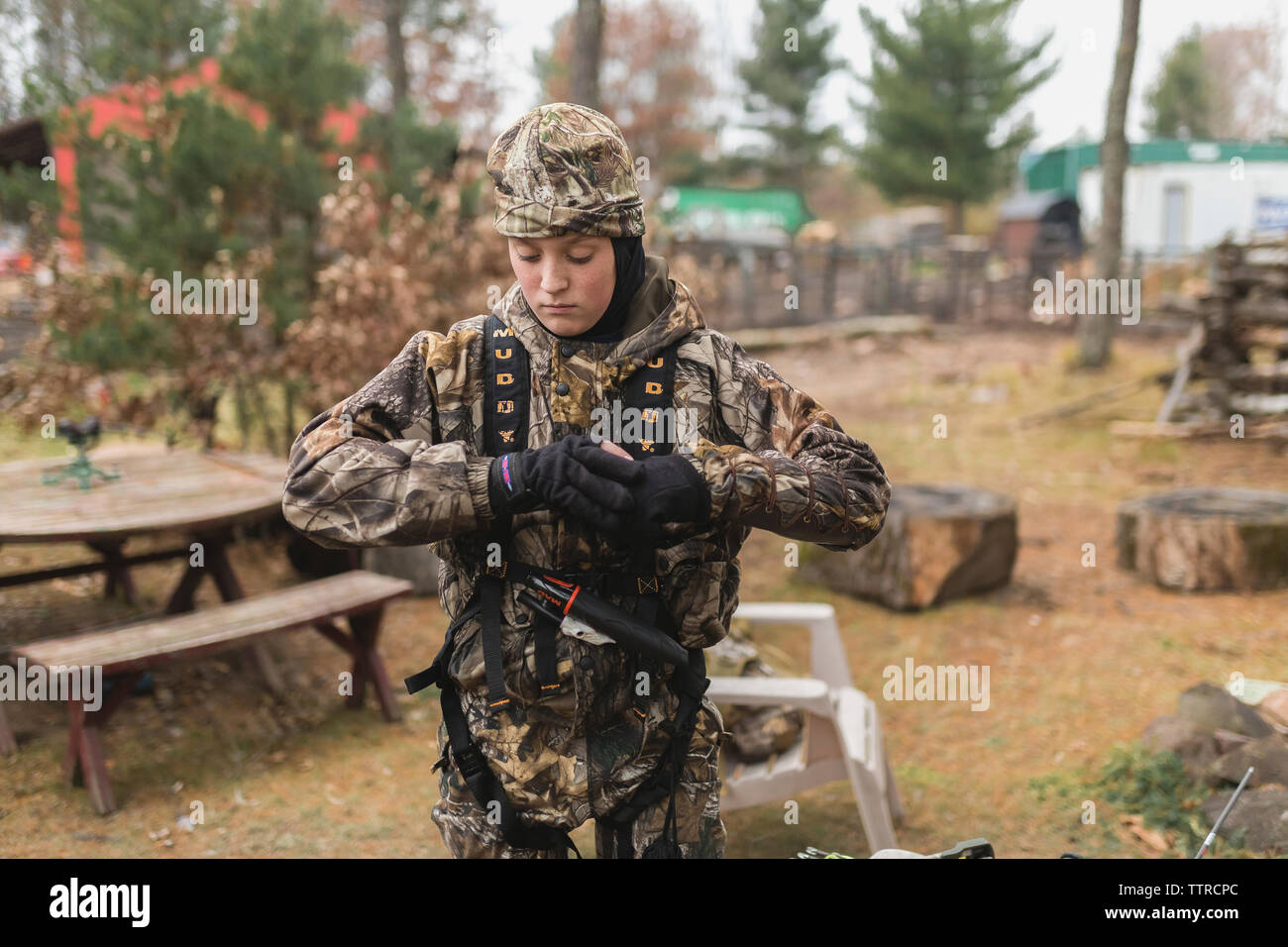 Ragazzo che indossa Abbigliamento camouflage mentre si sta in piedi sul campo Foto Stock