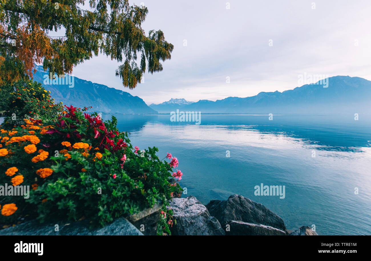 Tranquillo paesaggio del lago da montagne contro il cielo nuvoloso Foto Stock