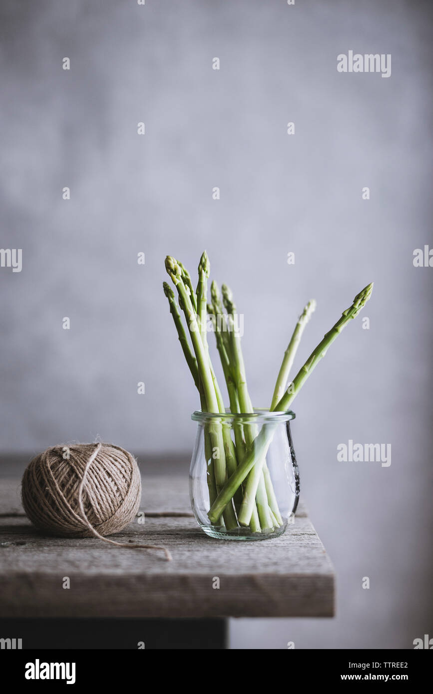 Gli asparagi e la sfera di lana sul tavolo di legno Foto Stock