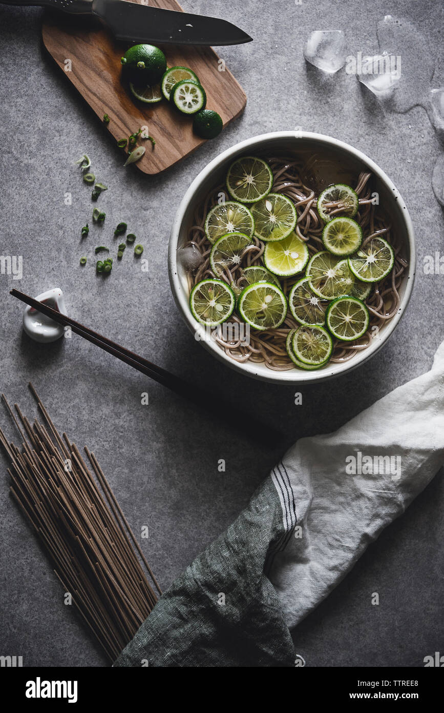 Angolo alto vista la sua pasta di soba servita nella ciotola con bacchette sul banco di cucina Foto Stock