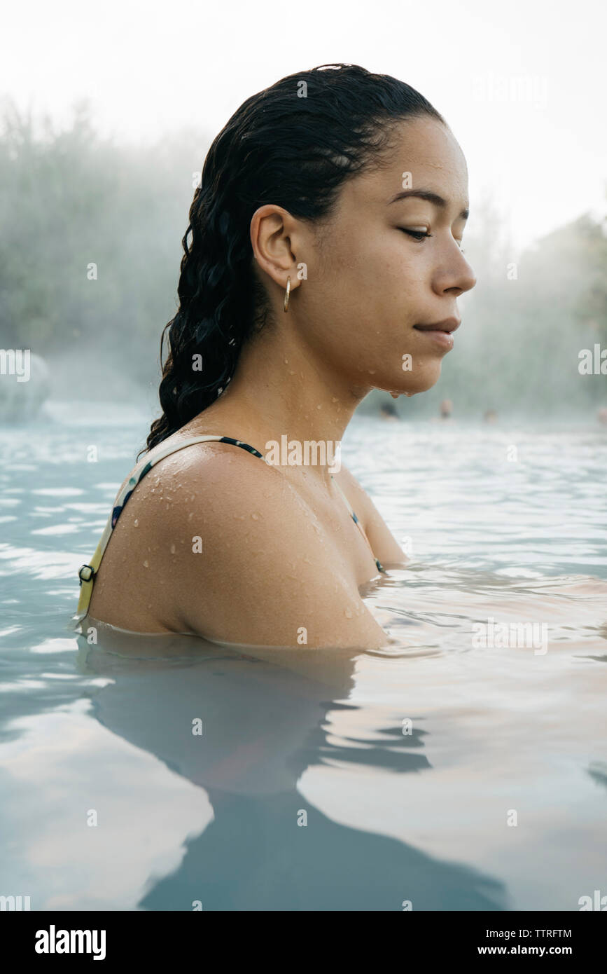 Vista laterale della donna in piscina termale Foto Stock