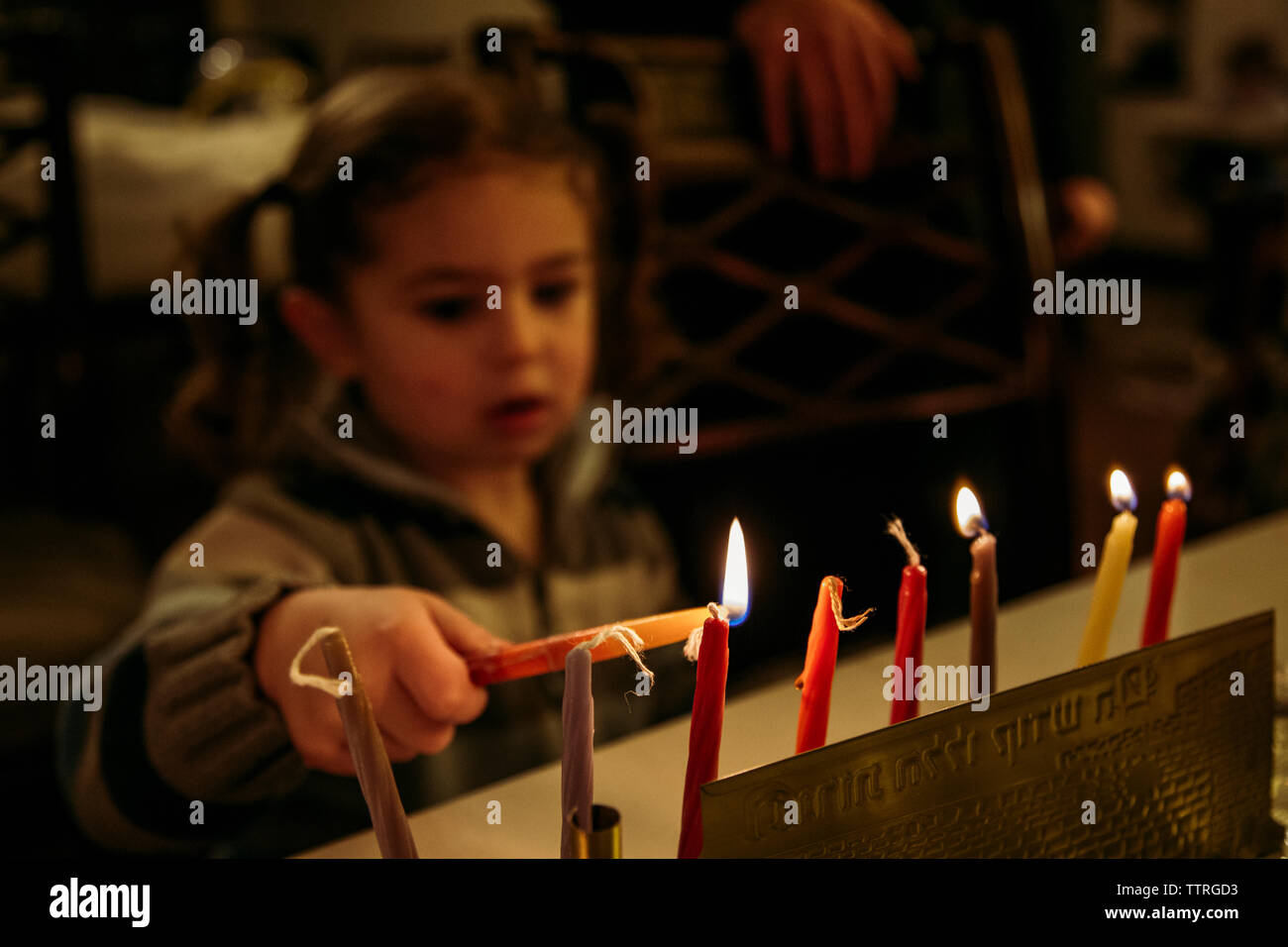 Close-up della ragazza di accensione di candele durante Chanukah Foto Stock