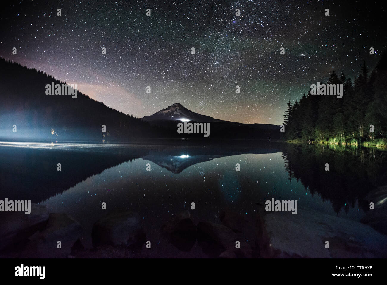 Vista panoramica delle montagne e lago contro il cielo stellato di notte Foto Stock
