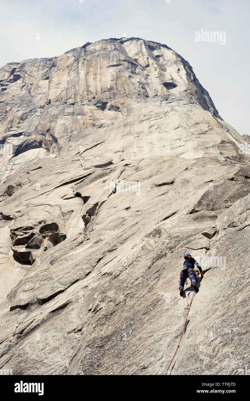 Basso angolo di visione della donna montagna arrampicata Foto Stock