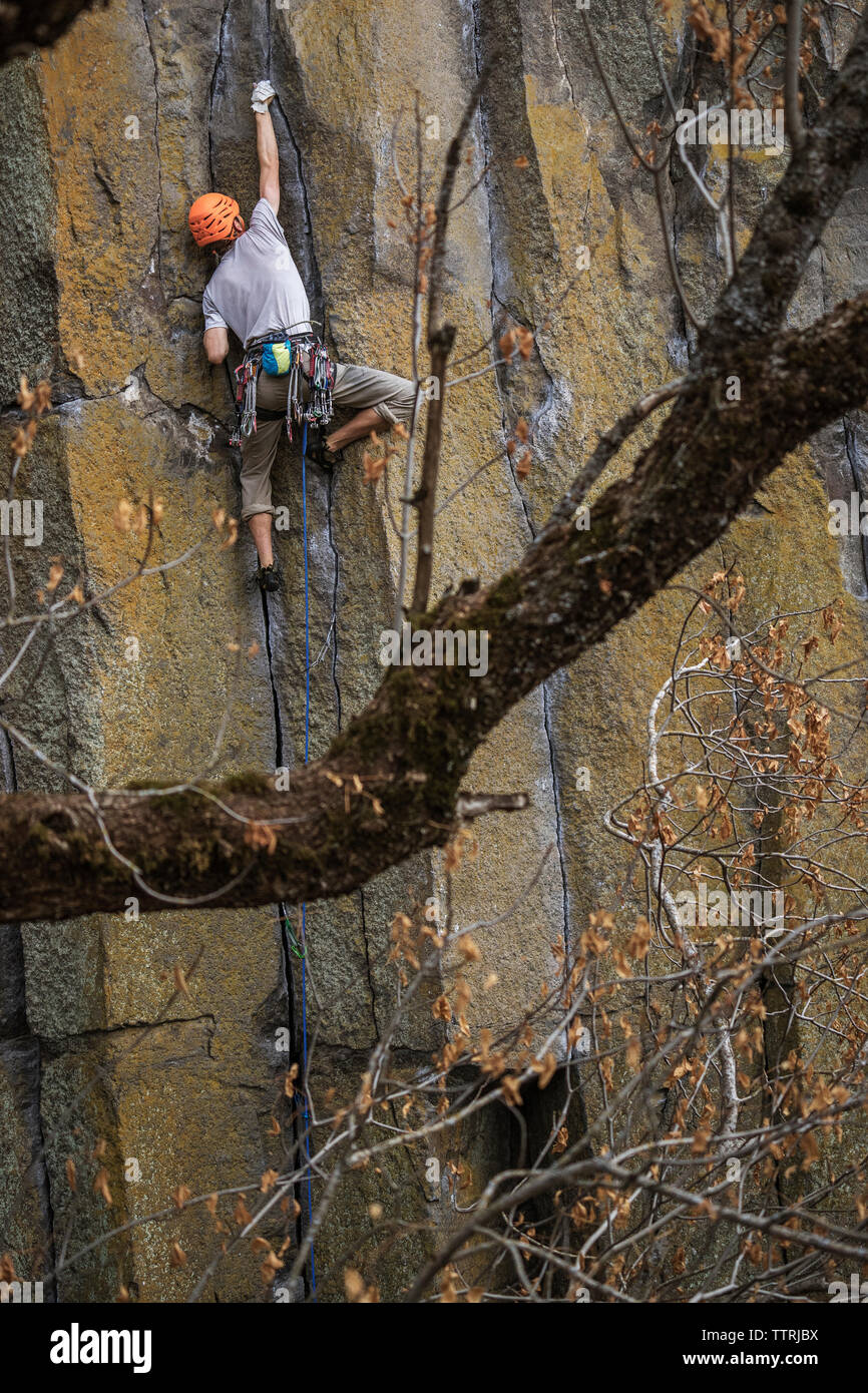 Basso angolo di visione di un escursionista rock climbing Foto Stock