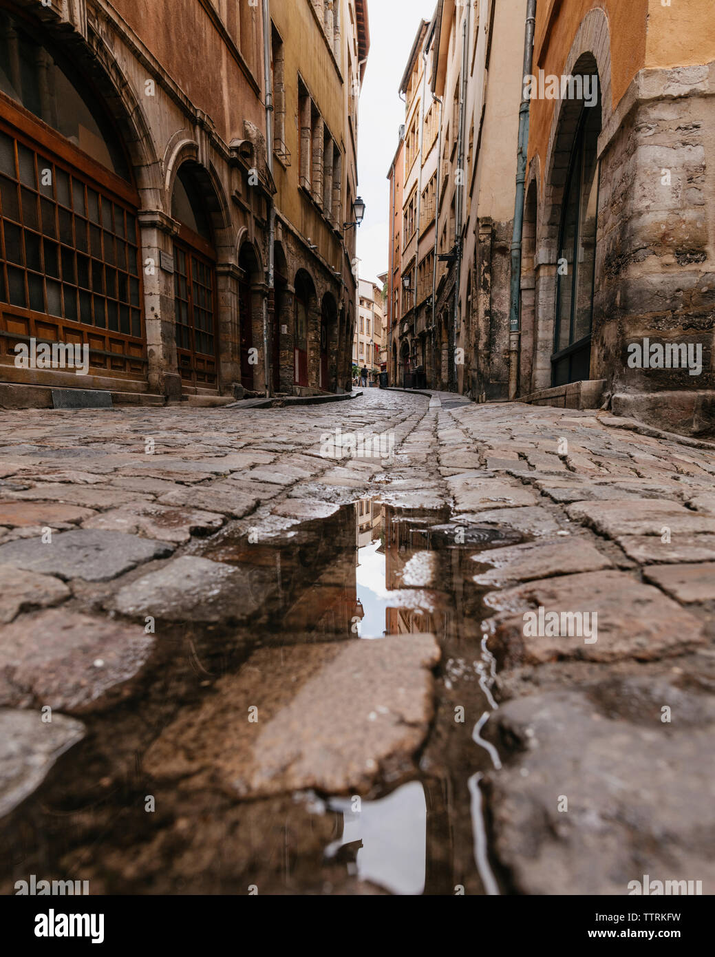 Superficie di livello immagine della pozzanghera sulla strada in mezzo a edifici in città Foto Stock