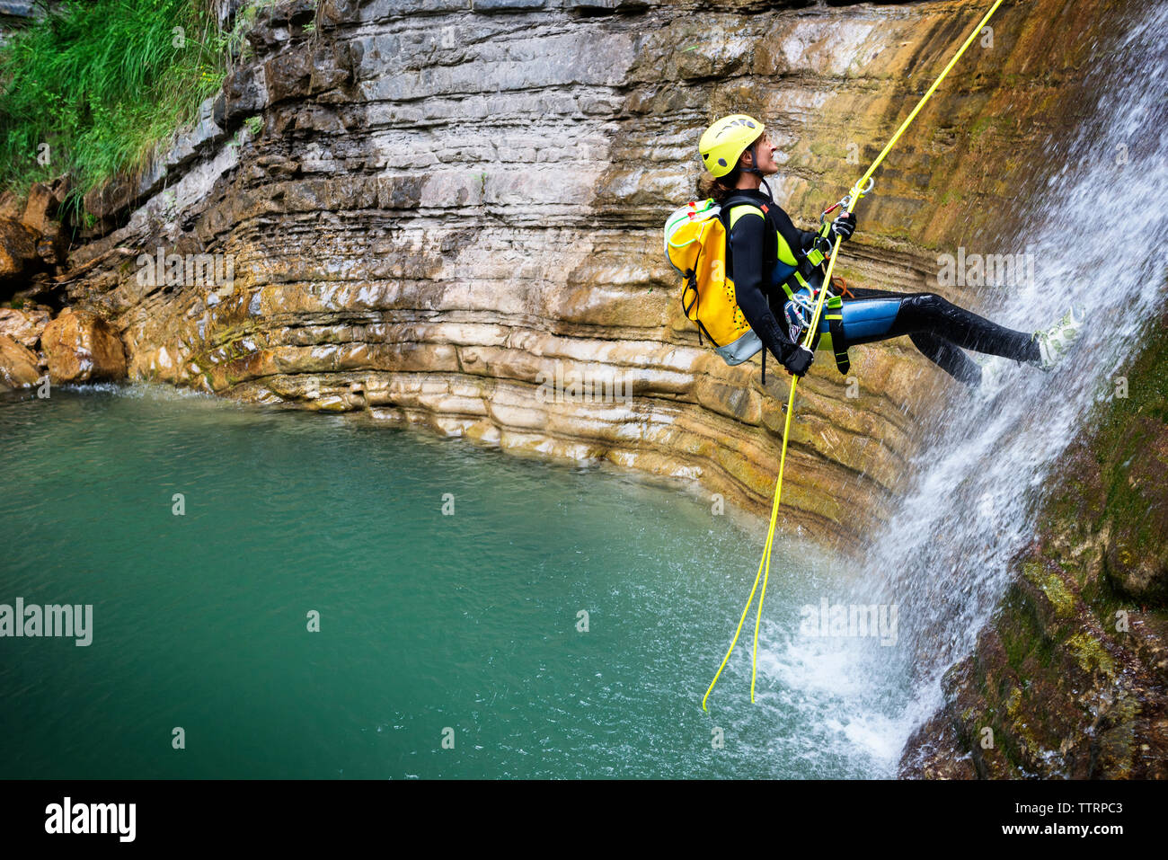 Vista laterale della donna rappelling scende fino al lago Foto Stock