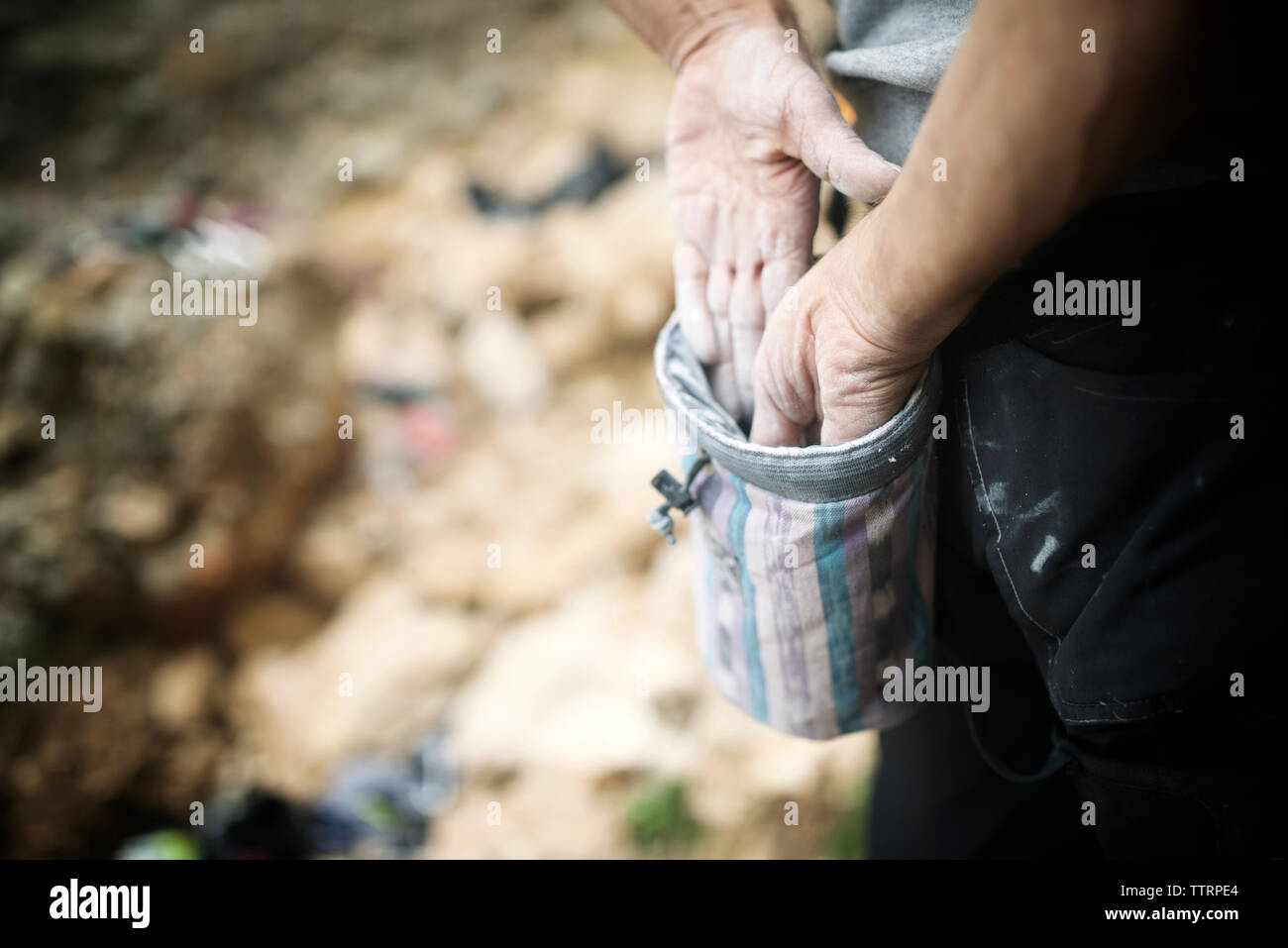 Mani tagliate di un escursionista l'applicazione di polvere di magnesio dal sacco Foto Stock