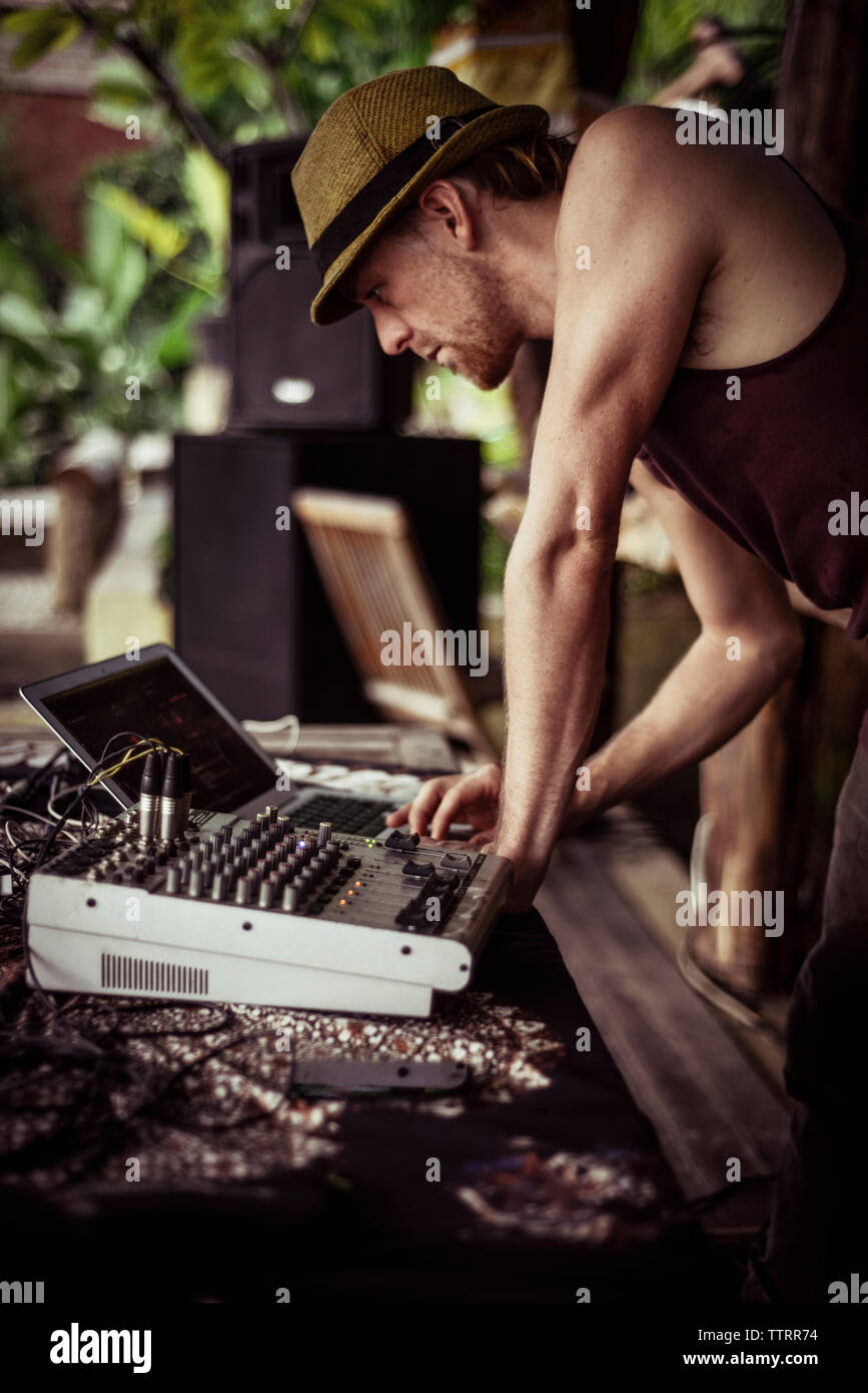 Uomo di funzionamento Mixer audio con computer portatile a tavola Foto Stock