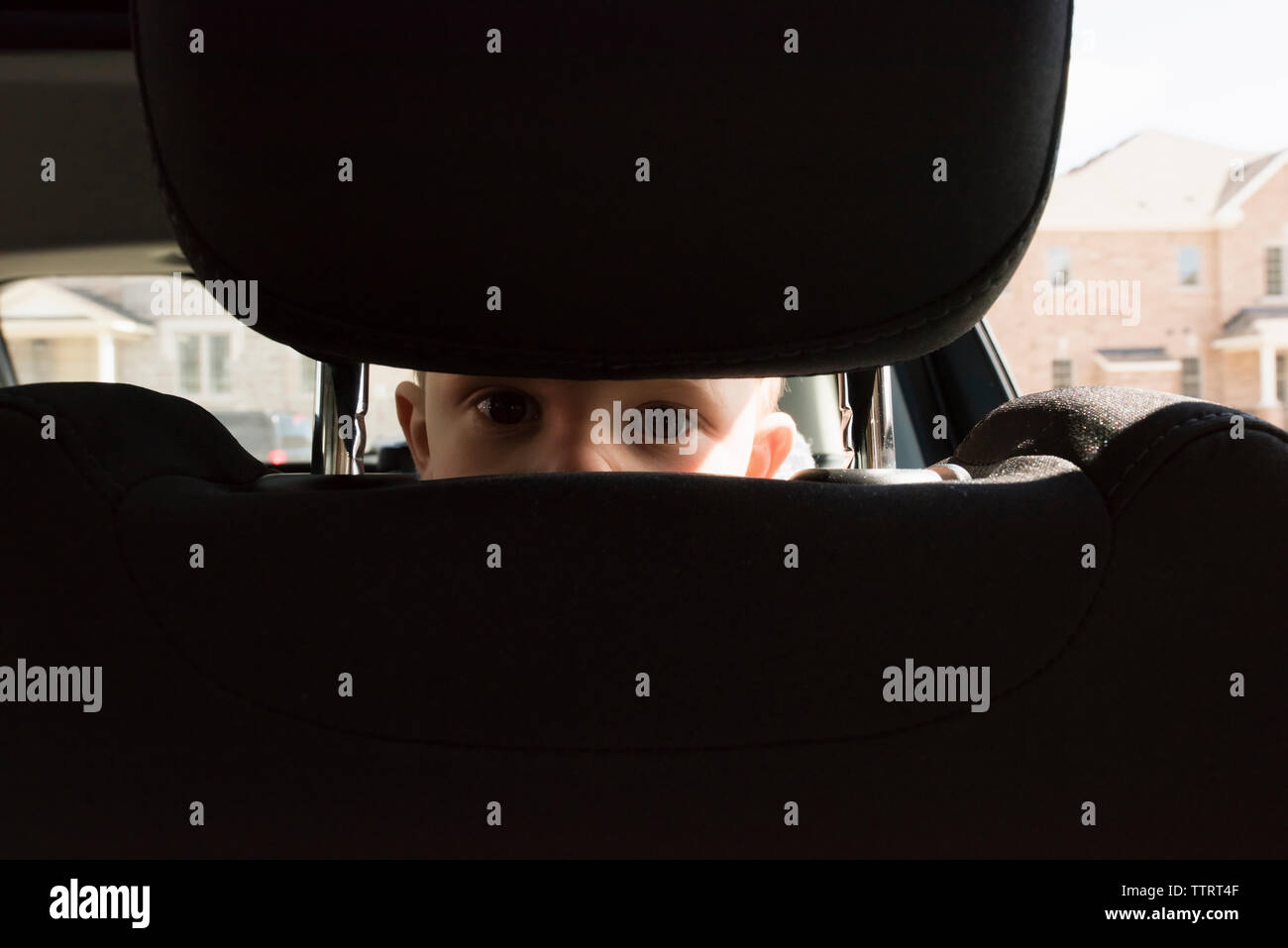 Ritratto di ragazzo spiata attraverso la sede in auto Foto Stock
