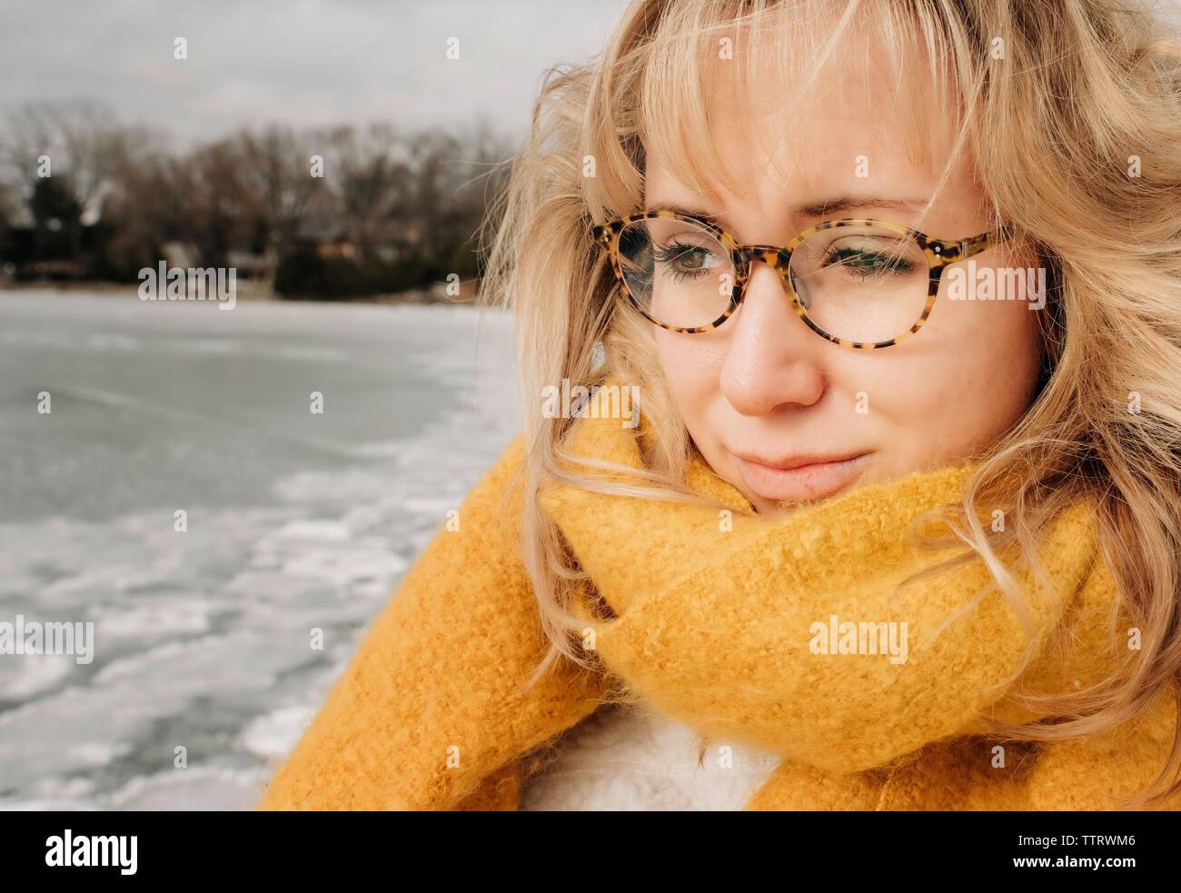 Ritratto di donna bionda con gli occhiali a guardare l'acqua sorridente Foto Stock