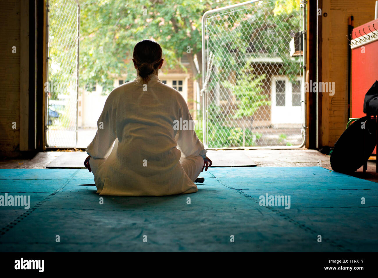 Vista posteriore della donna meditando in palestra Foto Stock