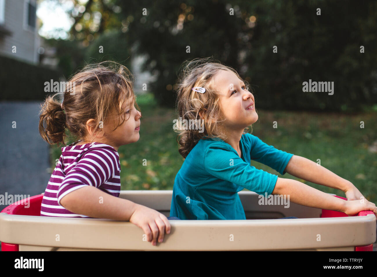 Due graziosi bambine sedersi felicemente insieme in un carro Foto Stock