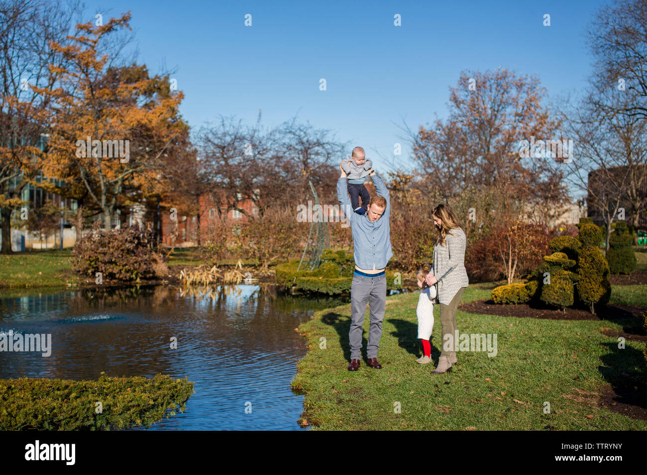 Una famiglia gioca insieme in un parco in autunno Foto Stock