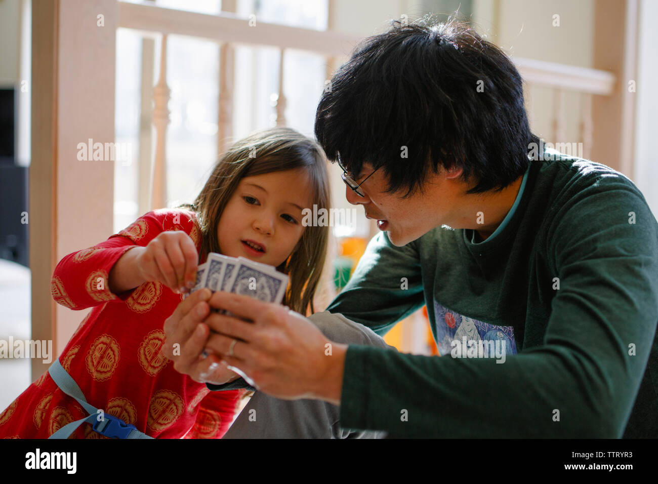 Padre e figlia la riproduzione di un gioco di carte a casa Foto Stock