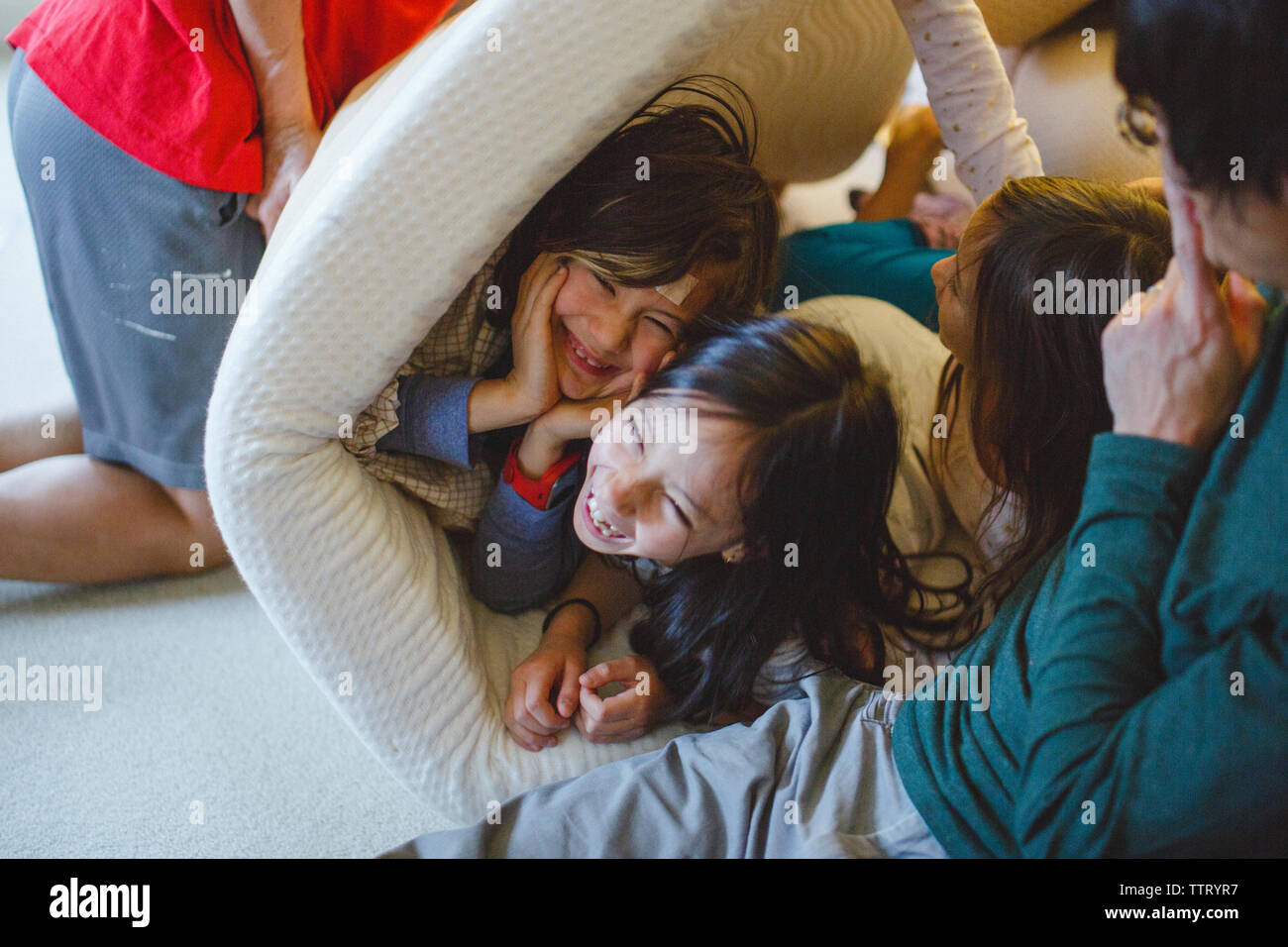 Una felice famiglia ridere giocando e wrestling insieme a casa Foto Stock