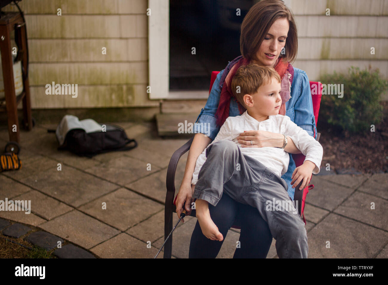 Una madre si siede fuori con il suo bambino in grembo Foto Stock