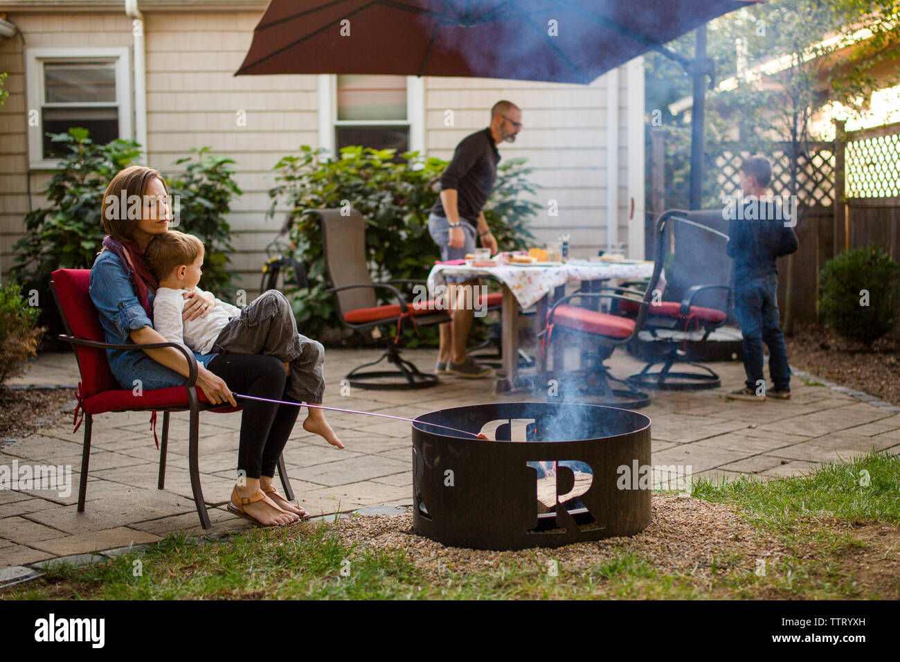 Una famiglia siede sulla loro patio prepara la cena insieme Foto Stock