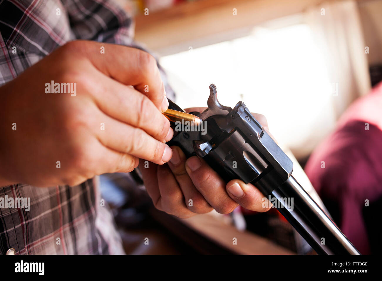 Close-up delle mani dell'uomo revolver di caricamento Foto Stock