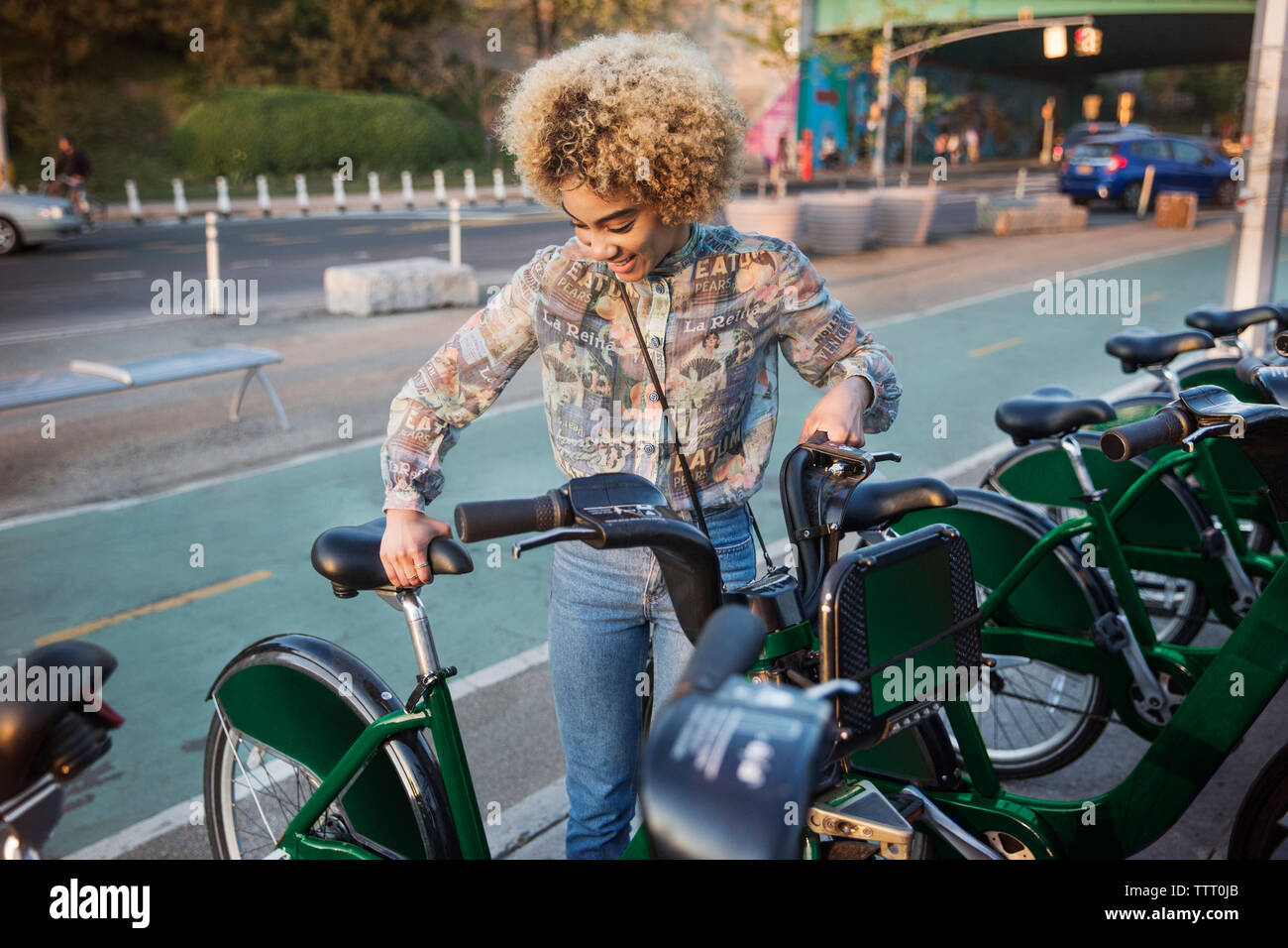 Donna felice affitto di bicicletta su una strada di città Foto Stock