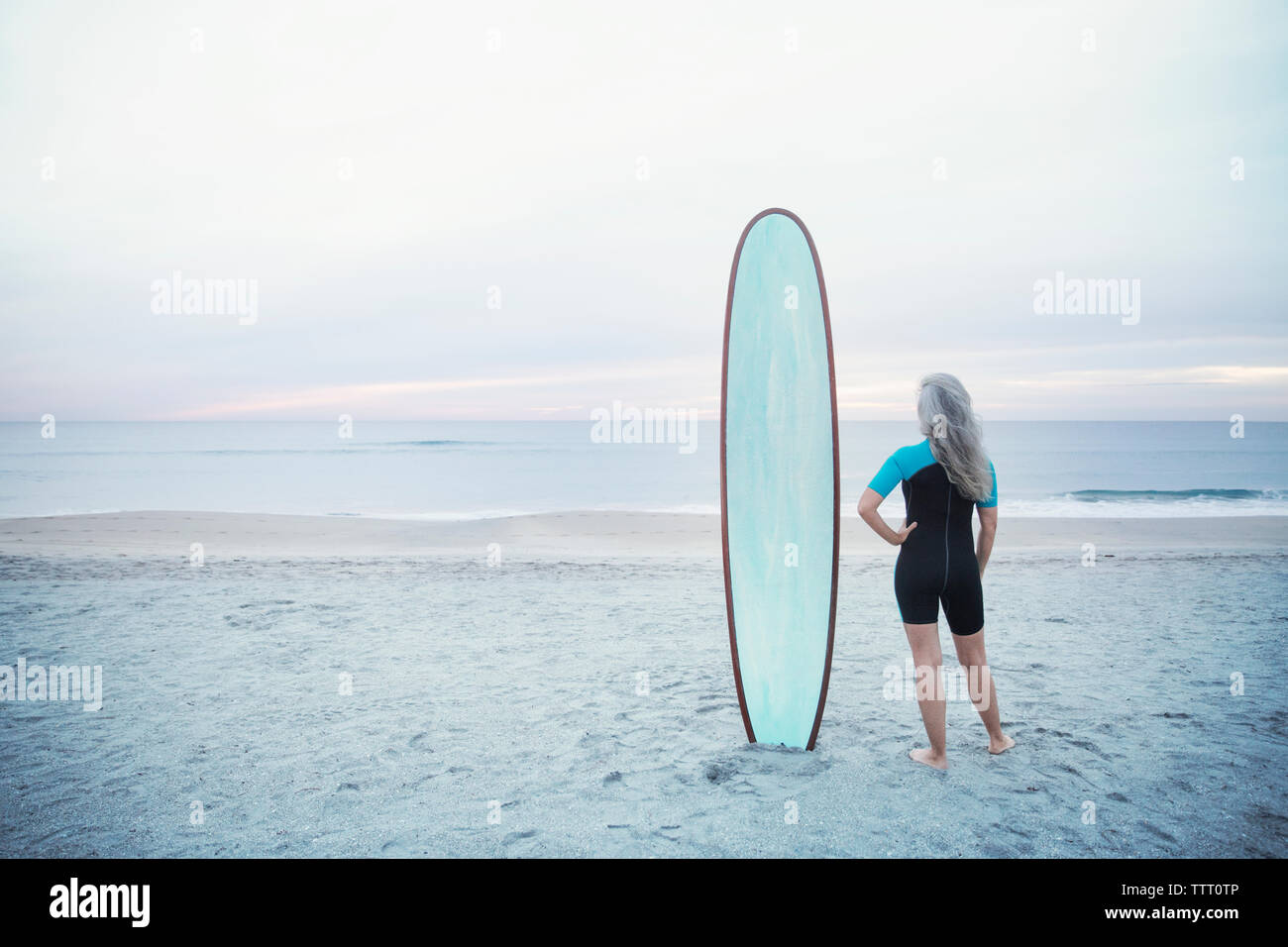 Vista posteriore del surfista femmina in piedi da tavola da surf su Delray Beach Foto Stock
