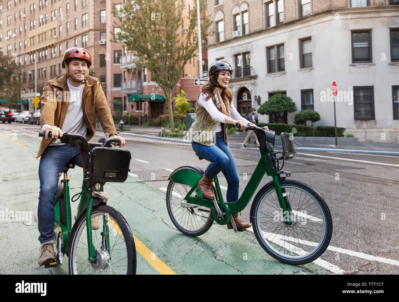 Coppia felice equitazione Bicicletta su una strada di città Foto Stock