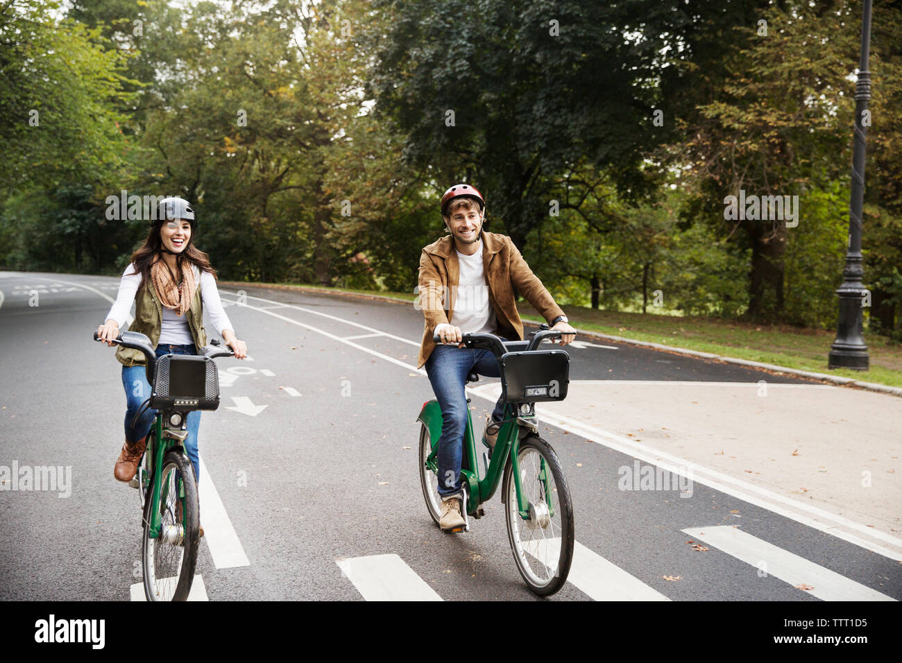 Allegro giovane equitazione bicicletta su strada in posizione di parcheggio Foto Stock
