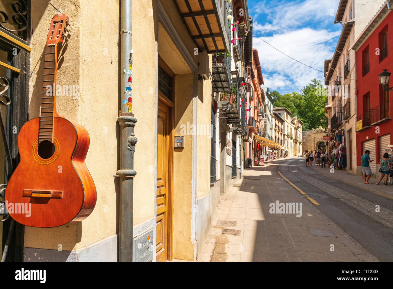 Chitarra Classica appesa sul muro di una casa tradizionale nella Cuesta de Gomerez street, Granada, Andalusia Foto Stock