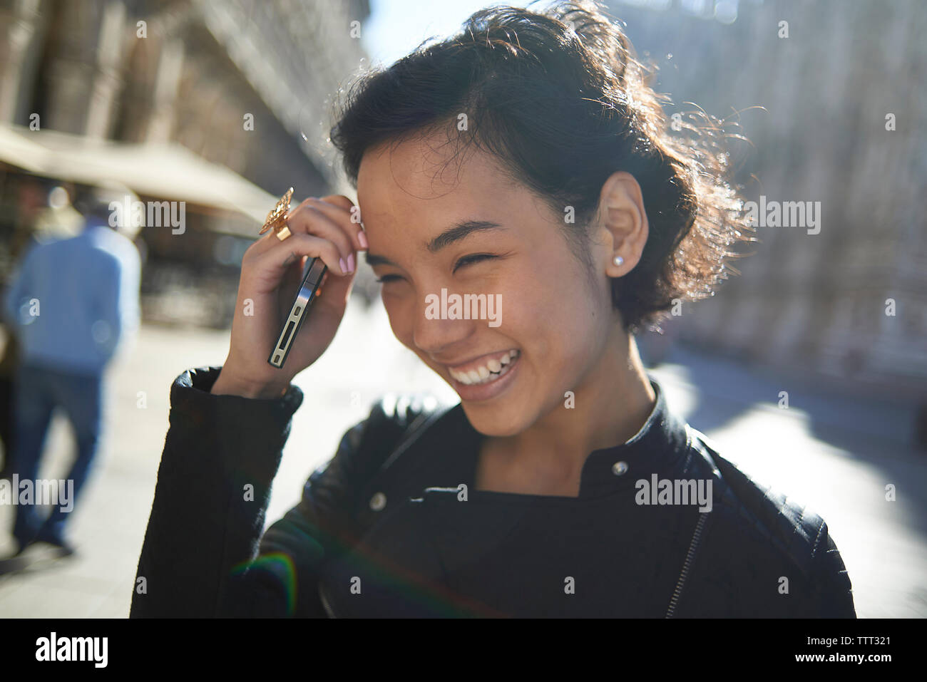 Donna felice con il cellulare in città Foto Stock