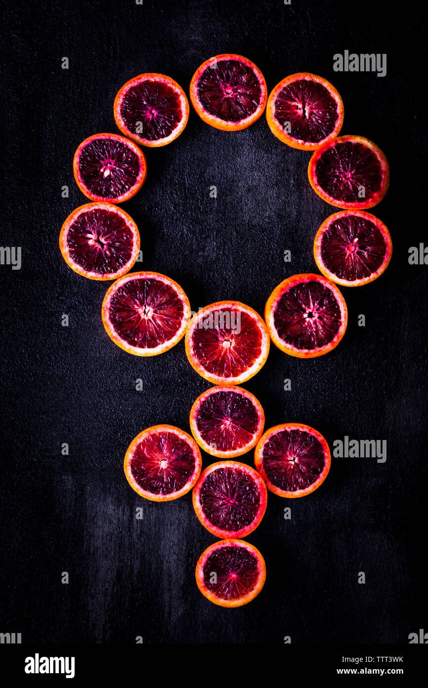 Vista aerea del simbolo femminile realizzato con arance sanguigne sulla tavola Foto Stock