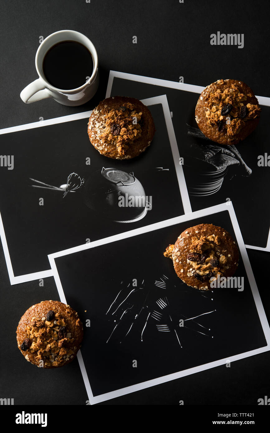 Angolo di alta vista di muffin con caffè e fotografie sul tavolo Foto Stock