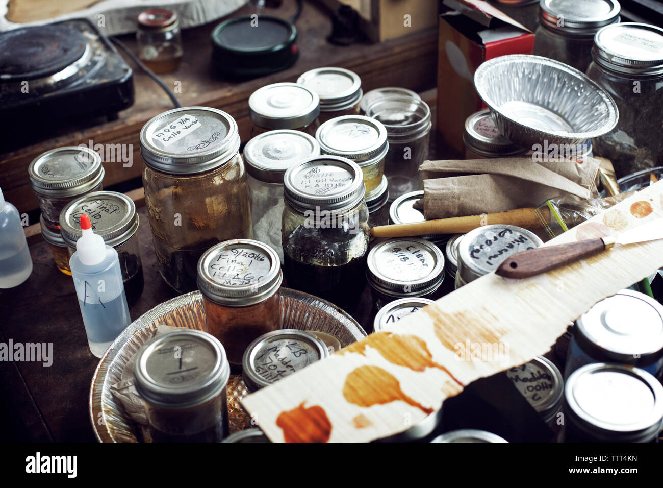 Angolo di alta vista di vasi e contenitori sul banco di lavoro in officina Foto Stock