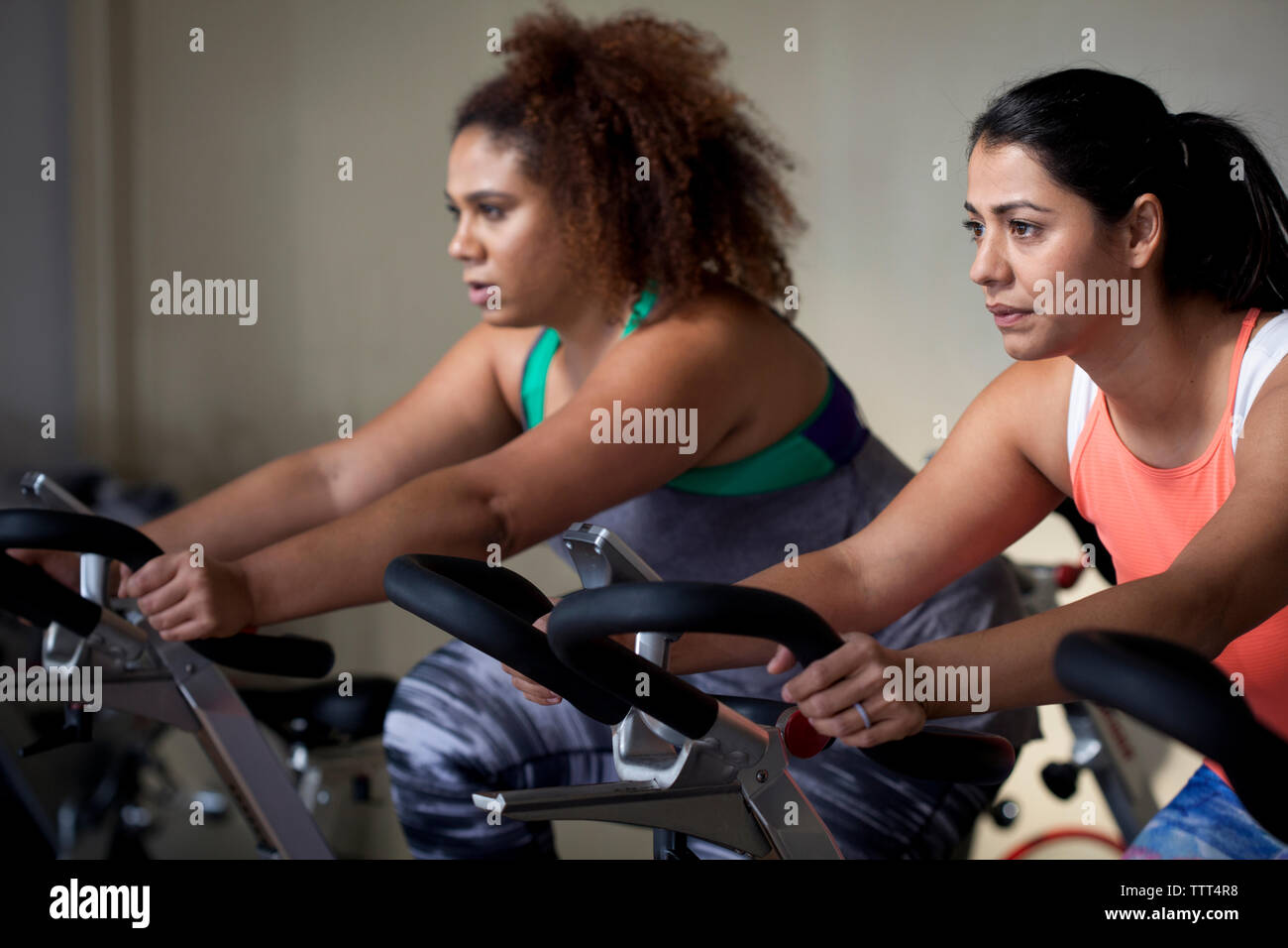 Amici di sesso femminile che esercitano sulla cyclette in palestra Foto Stock