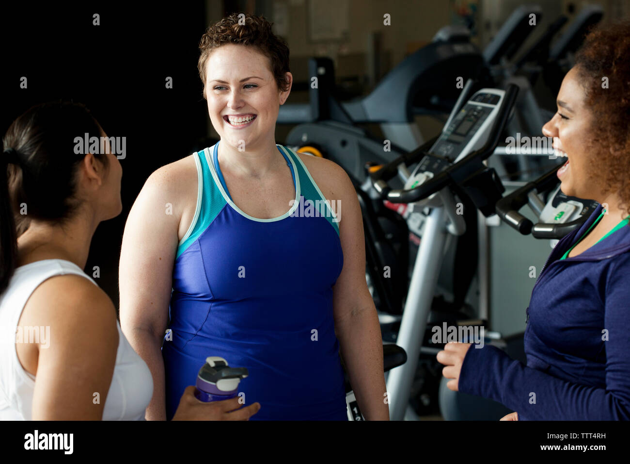 Amici di sesso femminile di parlare mentre in piedi in palestra Foto Stock