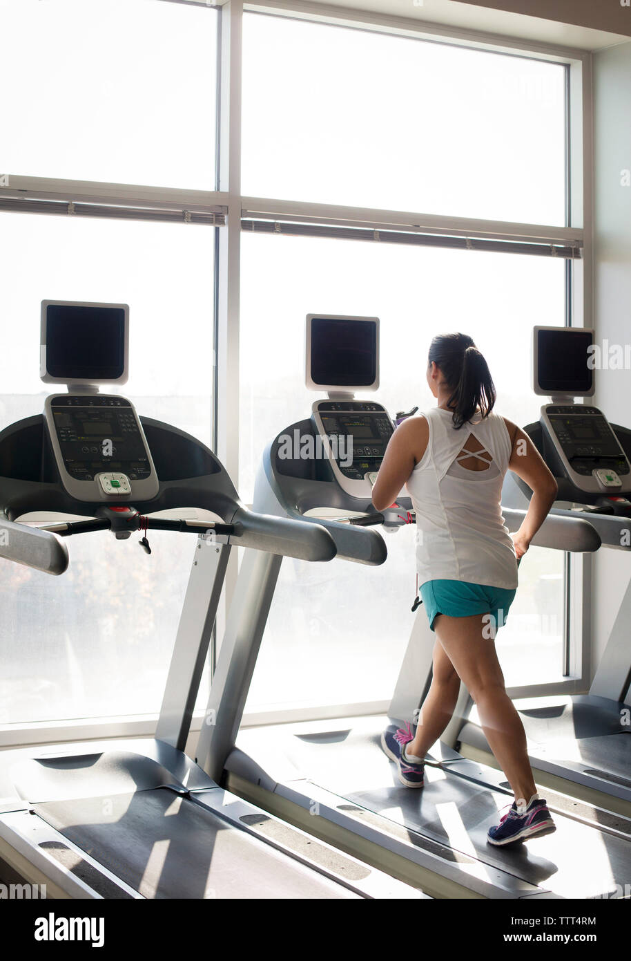 Per tutta la lunghezza della donna sul tapis roulant in palestra Foto Stock