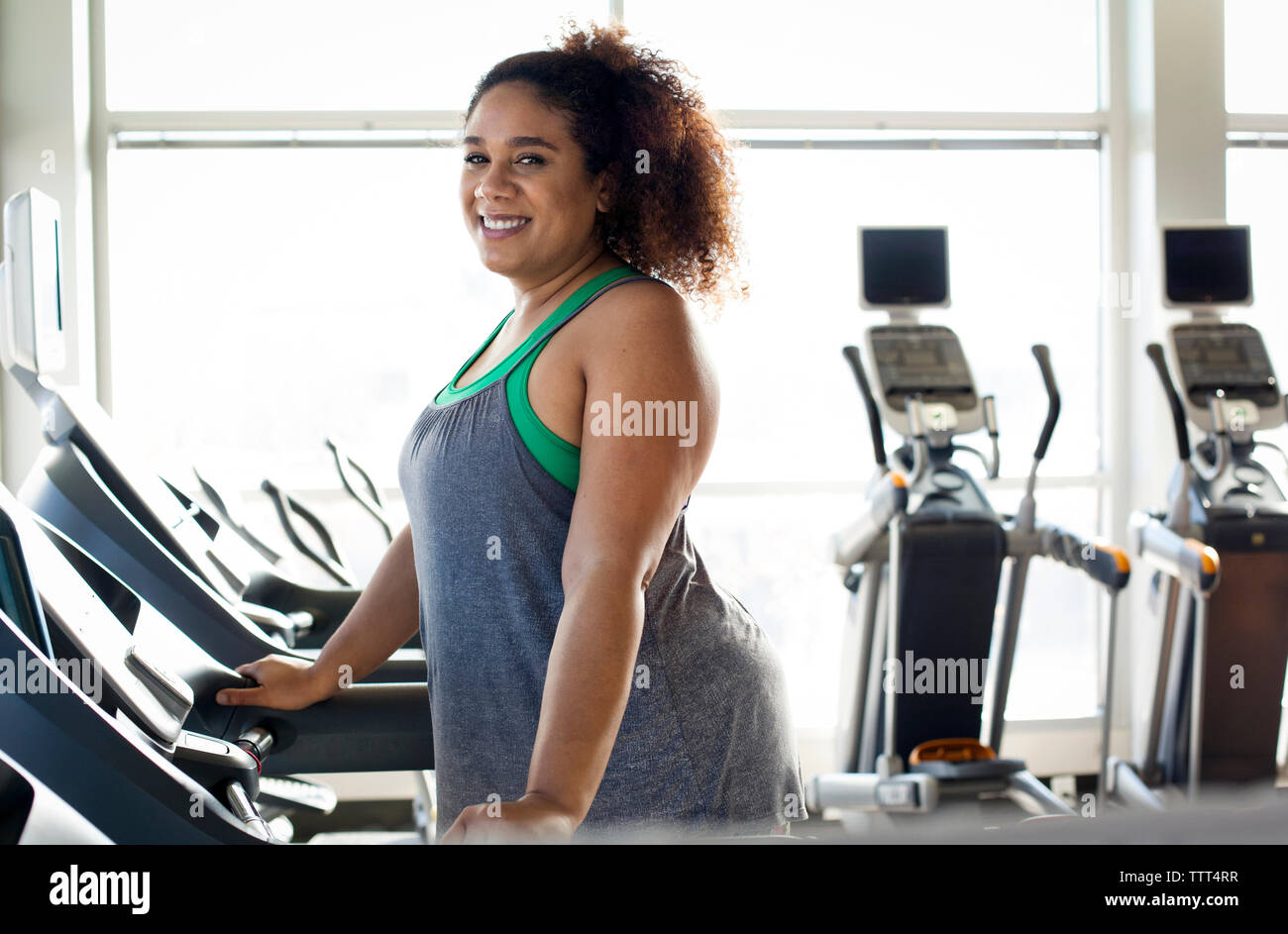 Ritratto di donna curva sul tapis roulant in palestra Foto Stock