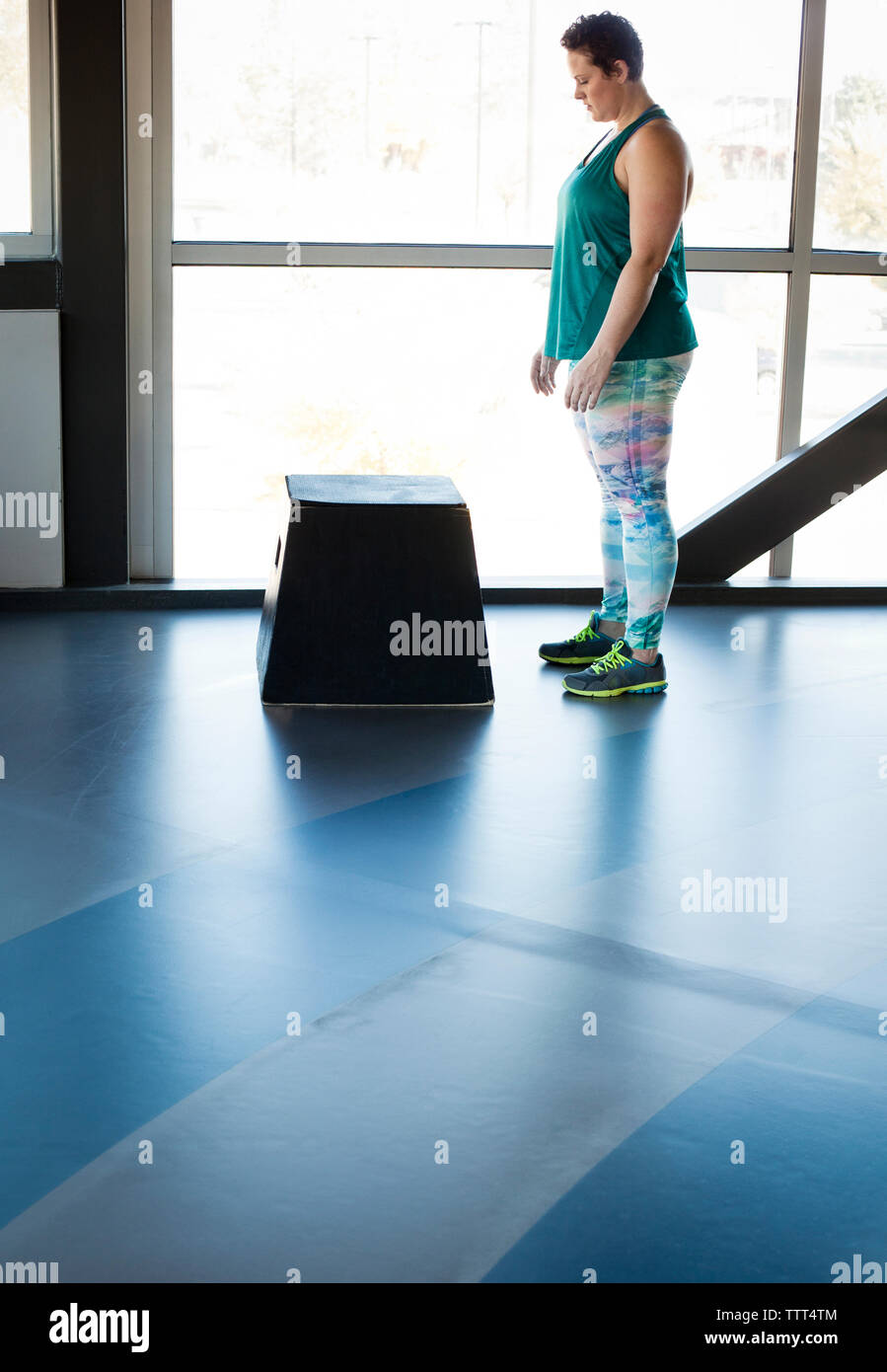 Per tutta la lunghezza della donna in piedi dalla casella in palestra Foto Stock