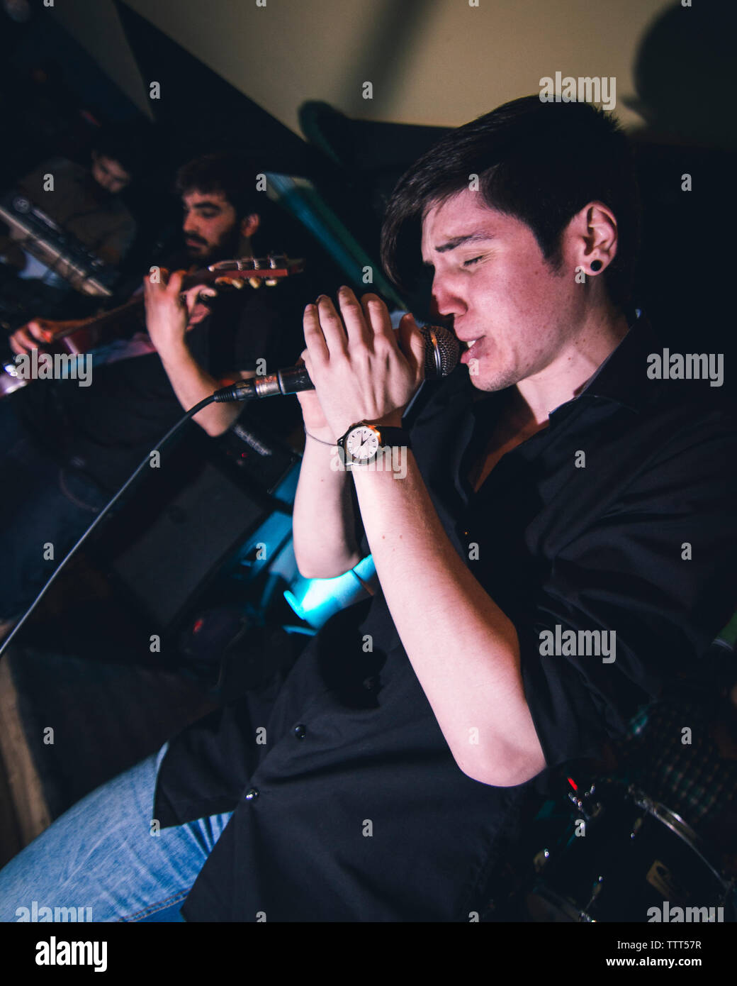 Basso angolo di visione dell uomo cantano mentre un collega a suonare la chitarra in discoteca Foto Stock