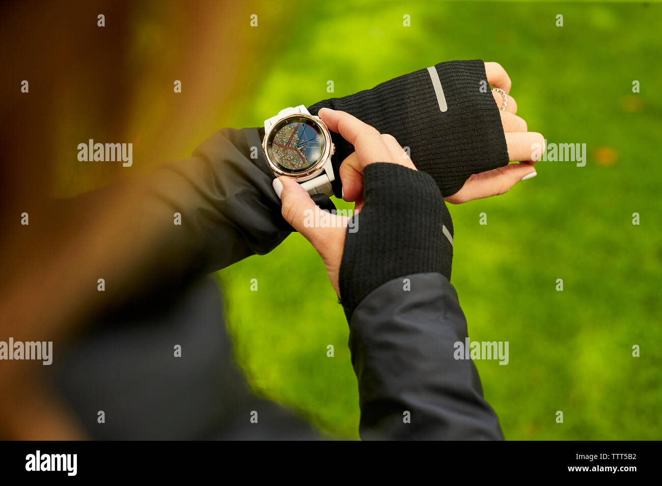 Un overhead shot di una donna che guarda la mappa sul suo orologio fitness. Foto Stock