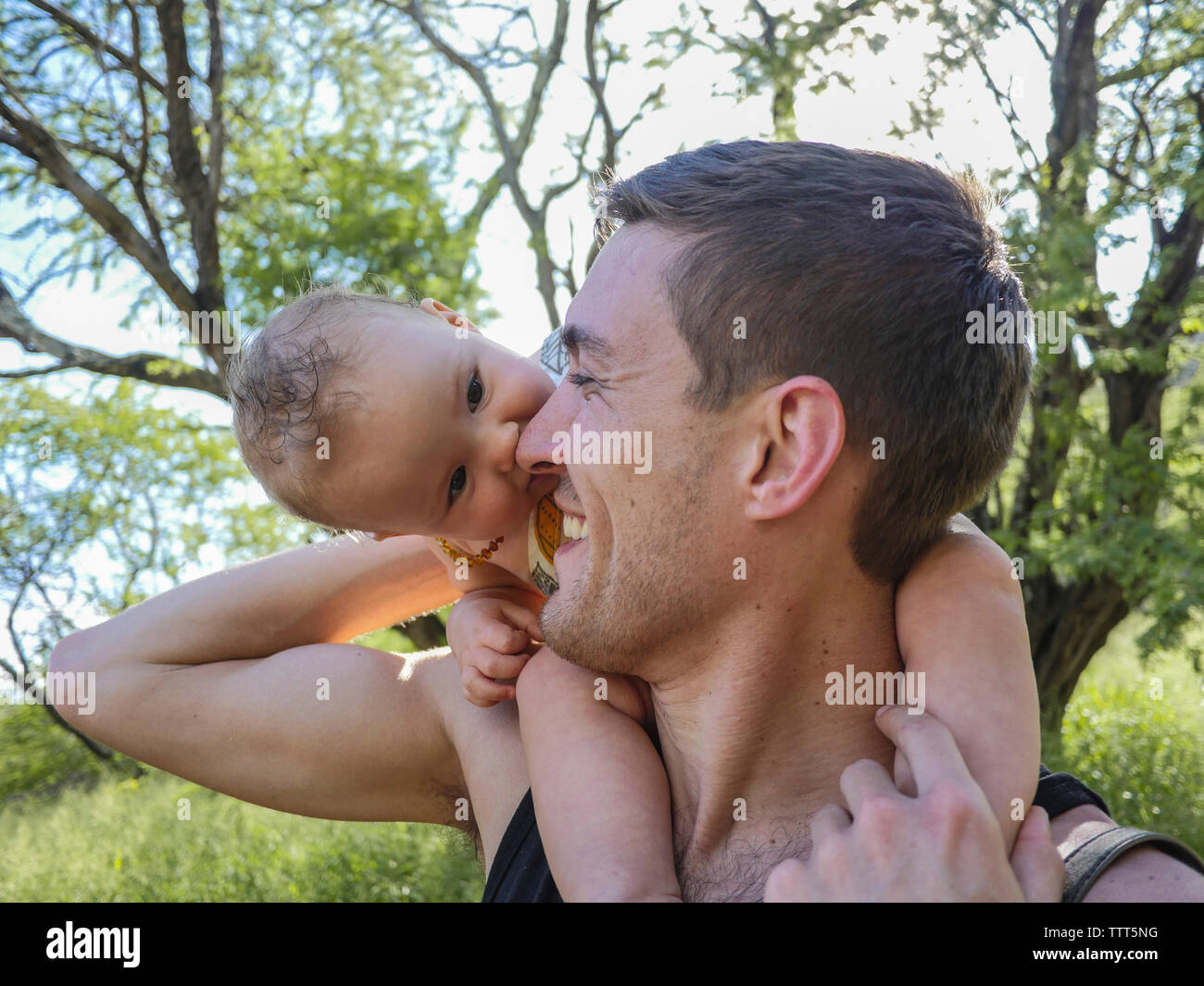 Close-up del padre che porta carino figlia sulle spalle in foresta Foto Stock